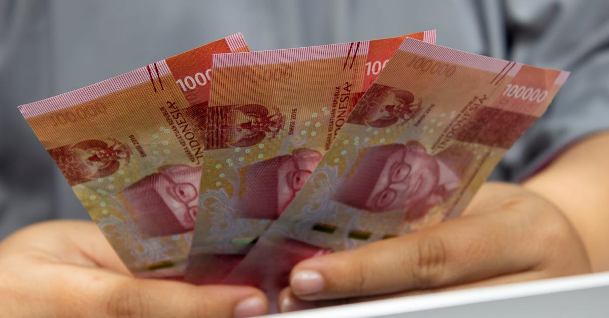 A person holding multiple Indonesian Rupiah banknotes, the currency that fell to a record 17,445 to the dollar before Bank Indonesia tightened FX rules