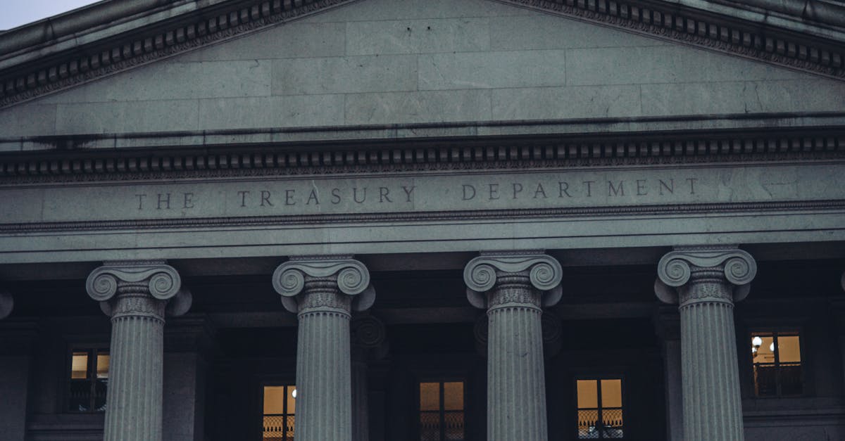 US Treasury Department building facade with columns and American flag at dusk