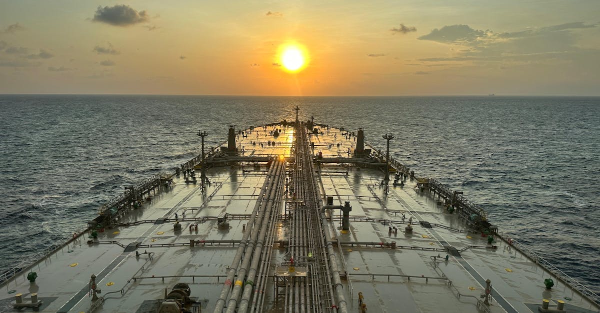 A large oil tanker sailing on the ocean with a sunset view