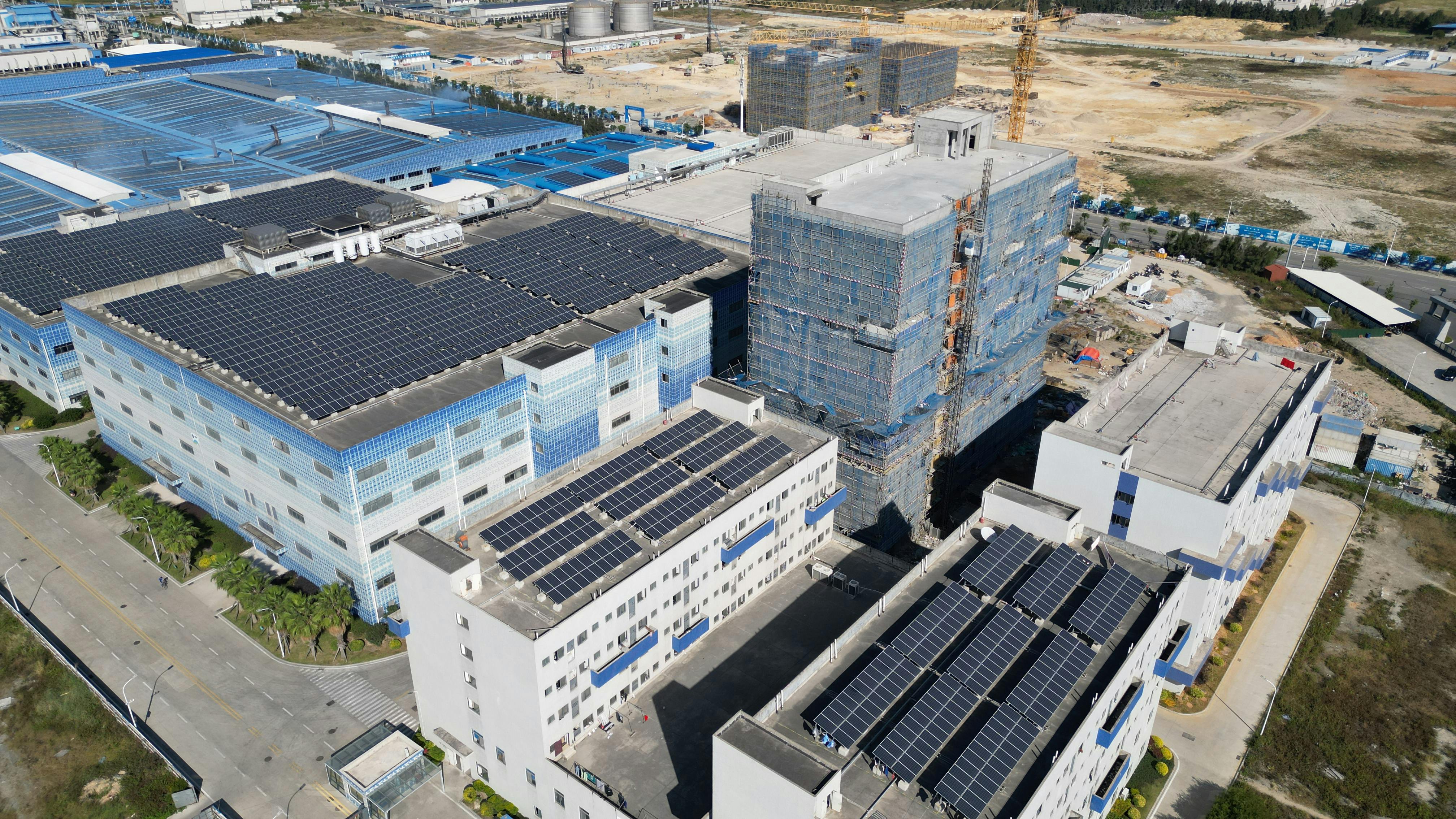 Aerial view of a modern industrial complex with rooftop solar panel installations