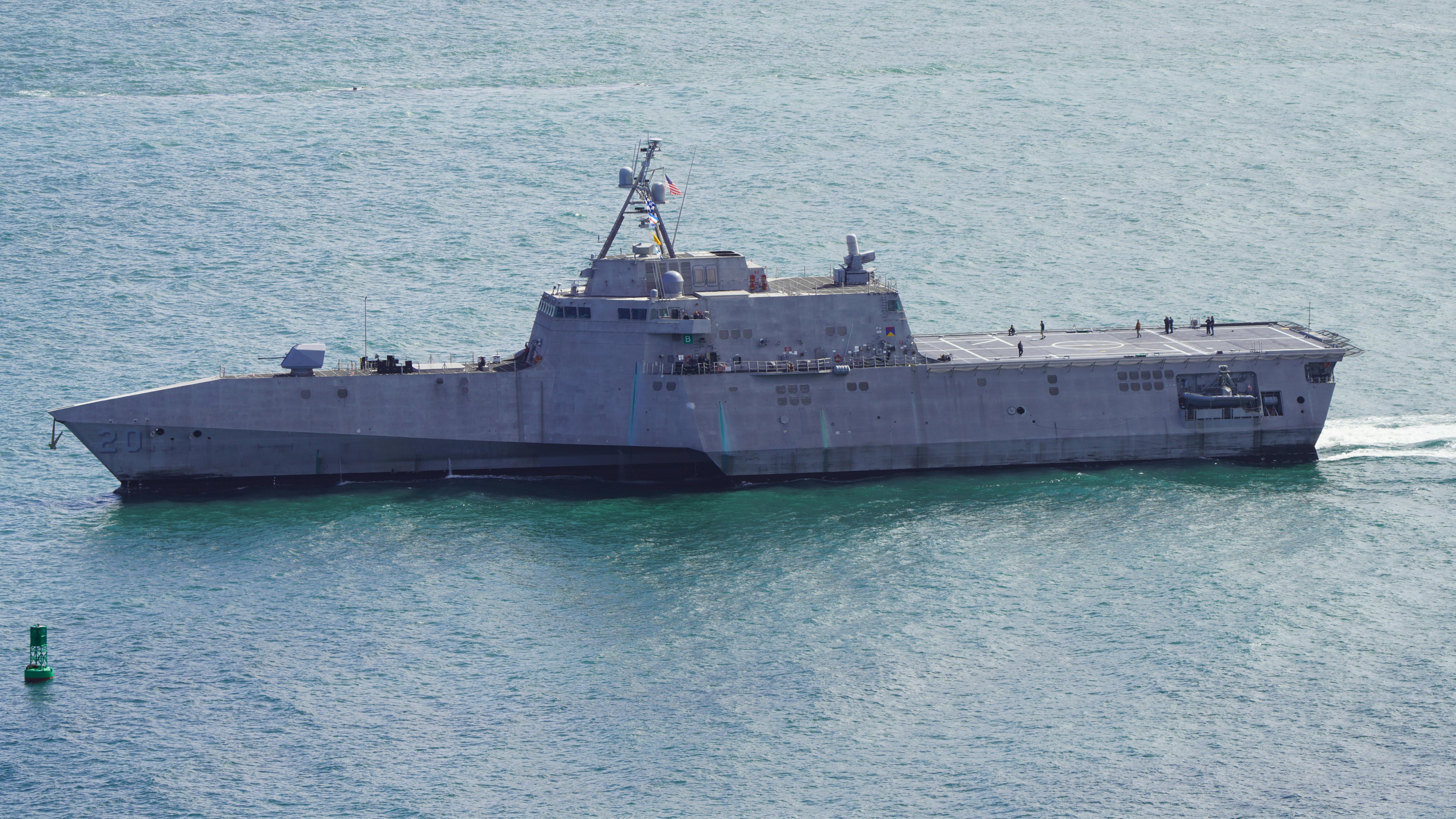 Modern navy warship cruising at sea under clear skies